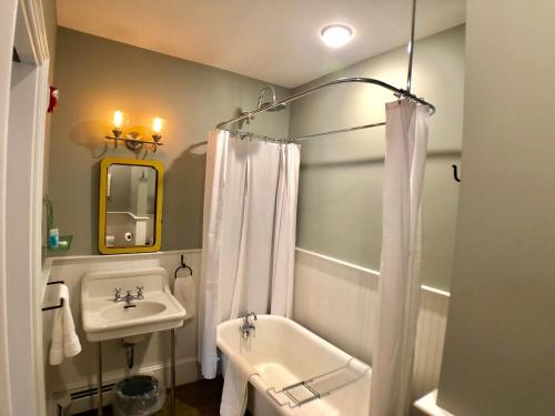 W łazience znajduje się umywalka, toaleta i prysznic. w obiekcie Mill Pond Inn w mieście Jefferson