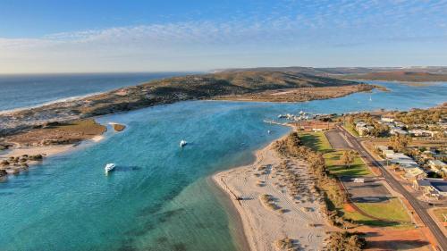 an aerial view of a beach with boats in the water at API Pelican Beach Front Apartments Kalbarri in Kalbarri