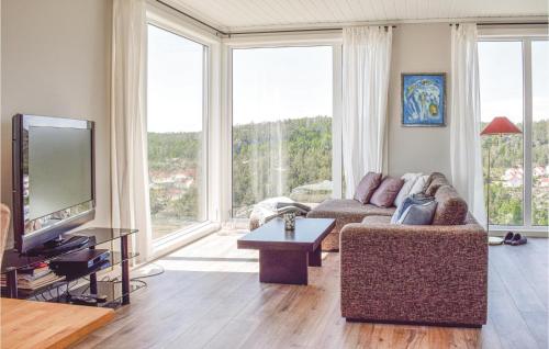 a living room with a couch and a tv at Four-Bedroom Holiday Home In Sondeled in Søndeled