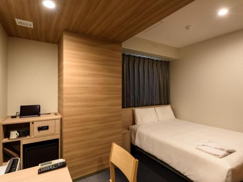 a small room with a bed and a desk at Henn na Hotel Premier Tokyo Asakusa Tawaramachi in Tokyo