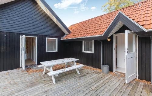 a picnic table on a wooden deck in front of a house at Three-Bedroom Holiday Home In Asperup in Asperup