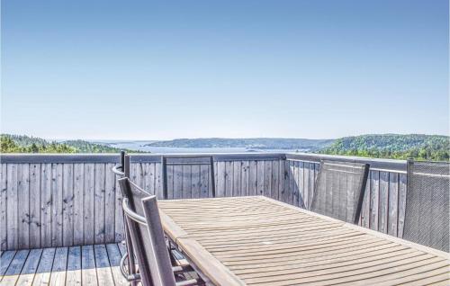 a wooden table on a deck with a view of the water at Four-Bedroom Holiday Home In Sondeled in Søndeled
