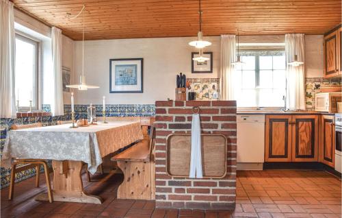 a kitchen with a table and a brick wall at Holiday Home Raketvejen in Øhuse