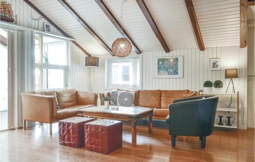 una sala de estar con un sofá y una mesa en Awesome Home In Hvide Sande With Sauna, en Bjerregård