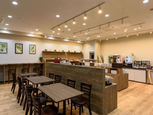 a restaurant with tables and chairs and a counter at Henn na Hotel Premier Tokyo Asakusa Tawaramachi in Tokyo