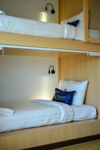 two bunk beds on a boat with a blue pillow at Phuket Airport Place in Nai Yang Beach