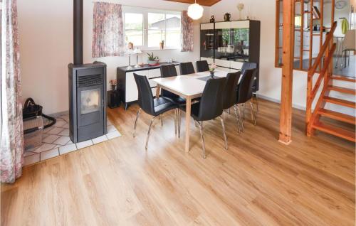 a dining room with a table and chairs and a fireplace at Two-Bedroom Holiday Home In Broager in Broager