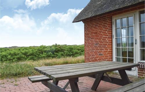 a wooden picnic table in front of a brick building at Holiday Home Raketvejen in Øhuse