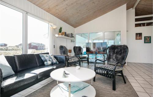 un soggiorno con un divano, sedie e un tavolo di Amazing Home In Løkken With Sauna a Løkken