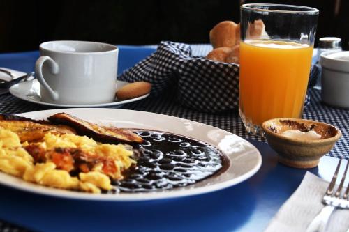 a plate of breakfast food and a glass of orange juice at 7 orejas in Quetzaltenango