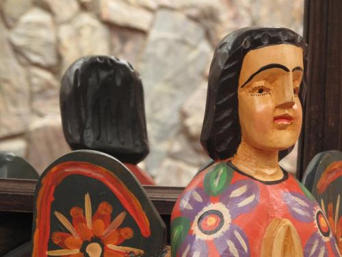 a wooden figurine of a woman with at 7 orejas in Quetzaltenango