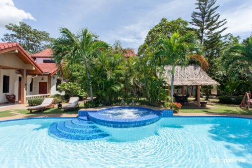 a large swimming pool in front of a house at Long Beach Inn in Sam Roi Yot