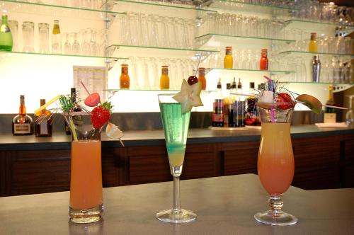 three cocktails sitting on a table in a bar at Le Robinson in Saint-Jean-de-Monts