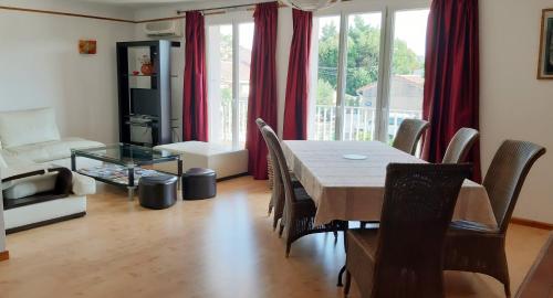 une salle à manger avec une table et des chaises et un salon dans l'établissement Appart Ensoleillé Proche Remparts, à Avignon