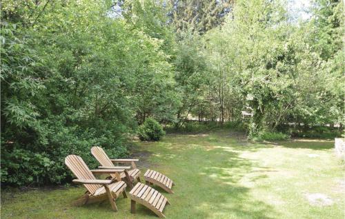 two chairs and a table in a yard with trees at Two-Bedroom Holiday Home Nibe With A Fireplace 06 in Farstrup