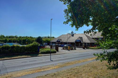 a house on the side of a road with a building at Best Western Manor Hotel in Gravesend