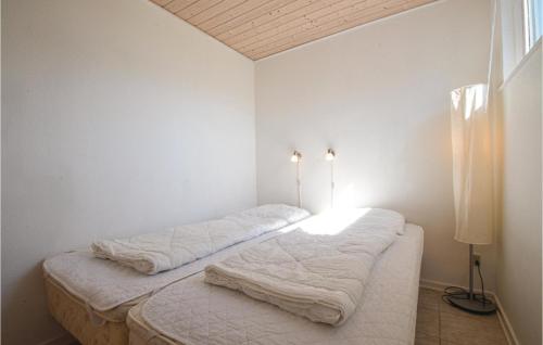 2 Betten in einem Zimmer mit weißen Wänden in der Unterkunft Terrassehus in Fæbæk