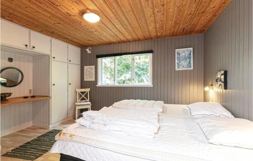 ein großes Bett in einem Schlafzimmer mit Holzdecke in der Unterkunft Borkjehuzed in Rønne