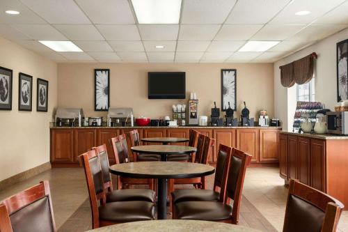 a restaurant with tables and chairs and a television at Ramada by Wyndham Pigeon Forge North in Pigeon Forge