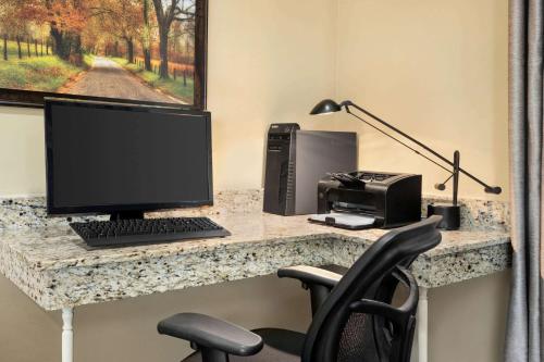 a desk with a computer and a printer on it at Ramada by Wyndham Pigeon Forge North in Pigeon Forge