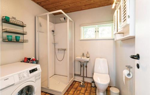 a bathroom with a washing machine and a sink at Borkjehuzed in Rønne