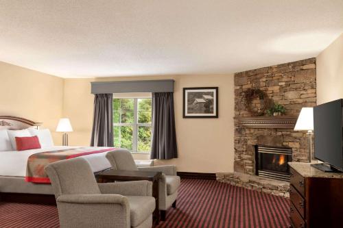 a hotel room with a bed and a fireplace at Ramada by Wyndham Pigeon Forge North in Pigeon Forge