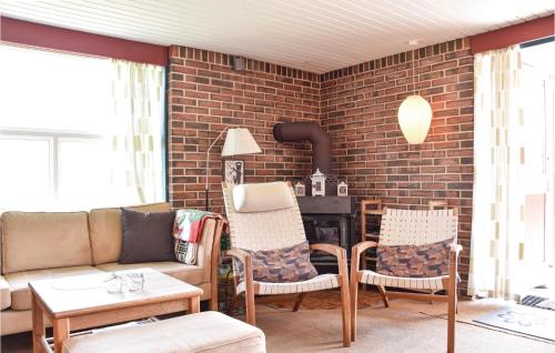 a living room with a couch and chairs and a brick wall at Holiday Home Lodbergsvej Ringkøbing Iii in Søndervig