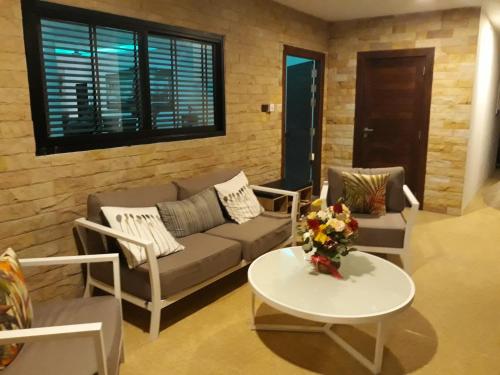 a living room with a couch and a table at Sunset Paradise Villa in Haad Pleayleam