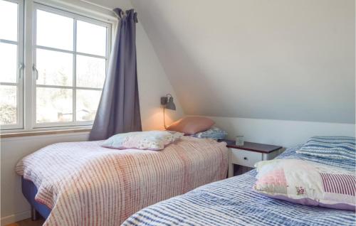 a bedroom with two beds and a window at Two-Bedroom Holiday Home In Haderslev in Haderslev