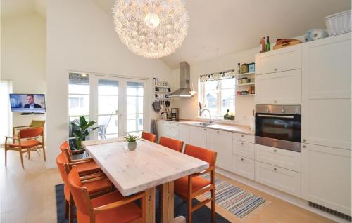 a kitchen with a table and chairs and a chandelier at Three-Bedroom Holiday Home In Nysted in Nysted