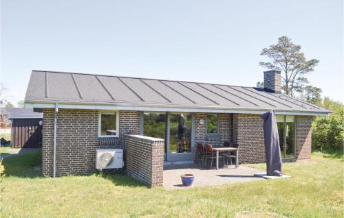 a brick house with a roof on a field at Three-Bedroom Holiday Home In Saby in Sæby