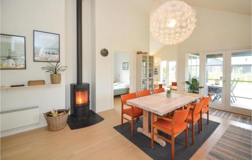a dining room with a table and a wood stove at Three-Bedroom Holiday Home In Nysted in Nysted