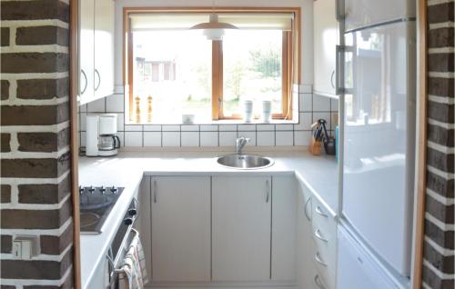 a white kitchen with a sink and a window at Three-Bedroom Holiday Home In Saby in Sæby