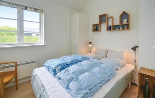 a bedroom with a bed with a blue comforter at Stunning Home In Nysted With Wifi in Nysted