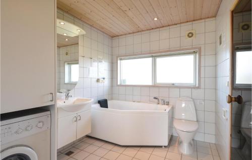 a bathroom with a tub and a toilet and a sink at Sndervig Ferieby in Søndervig