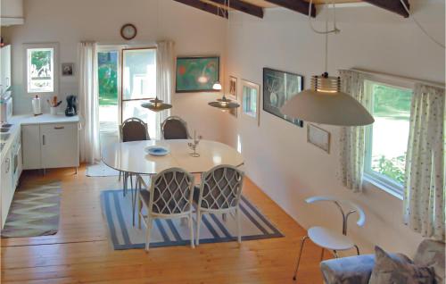 a kitchen and dining room with a table and chairs at Amazing Home In Skånes Fagerhult in Skånes Värsjö