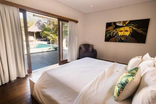 ein Schlafzimmer mit einem Bett und Blick auf einen Pool in der Unterkunft Seminyak Villa in Seminyak