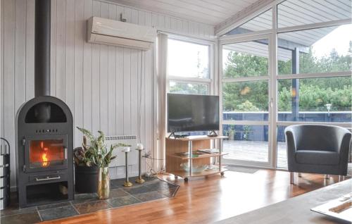 a living room with a fireplace and a television at Holiday Home Fyrrekrogen Vi in Lønne Hede