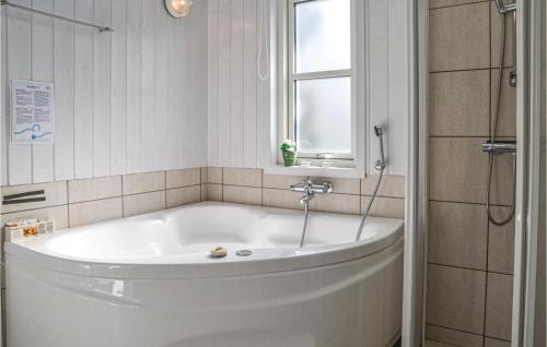 a white bath tub in a bathroom with a window at Awesome Home In Nrre Nebel With 5 Bedrooms, Sauna And Wifi in Lønne Hede