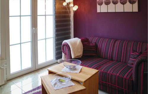 ヴァーネミュンデにあるGorgeous Apartment In Warnemnde With Kitchenの紫色のリビングルーム(ソファ、テーブル付)