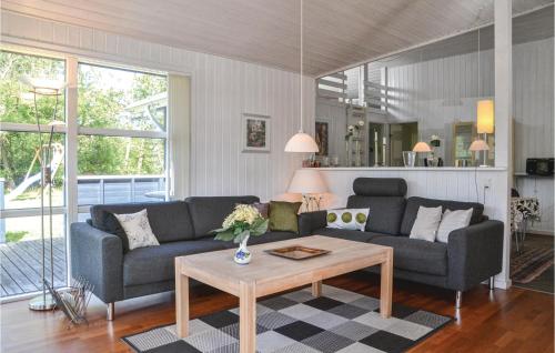 a living room with two couches and a coffee table at Holiday Home Fyrrekrogen Vi in Lønne Hede