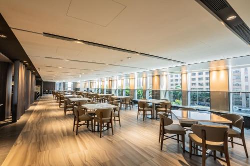 a dining room with tables and chairs and windows at Jin Shi Hu Hotel in Kaohsiung