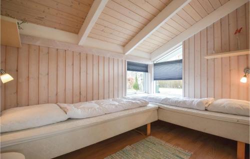 エーベルトフトにあるNice Home In Ebeltoft With 3 Bedrooms, Sauna And Wifiの木製の壁と大きな窓が備わる客室です。