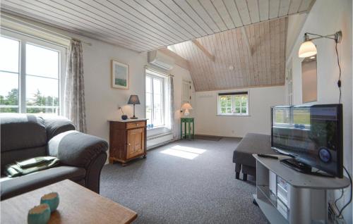 Una sala de estar con un sofá y un televisor. en One-Bedroom Holiday Home Rømø With Sea View 01, en Bolilmark