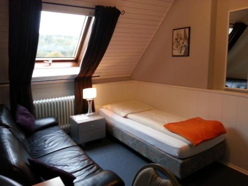 a small room with a bed and a window at Hotel Restaurant Klostermühle in Reutlingen