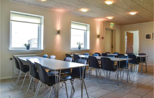 a conference room with tables and chairs and windows at Kabyssen in Thyborøn