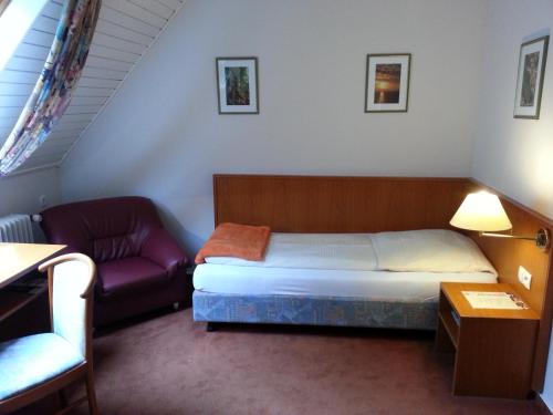 a small bedroom with a bed and a couch at Hotel Restaurant Klostermühle in Reutlingen
