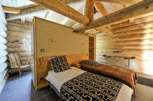 a bedroom with a bed in a room with wooden walls at Les Chalets de Maramour in Chazey-sur-Ain