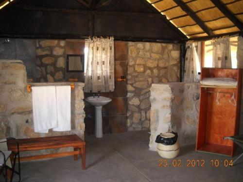 a room with a bathroom with a sink and a toilet at Kapika Waterfall Lodge in Epupa