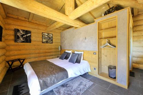 a bedroom with a bed in a wooden cabin at Les Chalets de Maramour in Chazey-sur-Ain